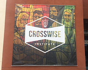 A Crosswise Institute banner hanging a building wall outside.