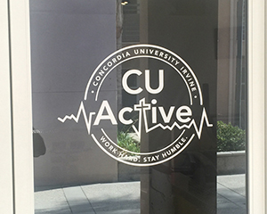 A window graphic on glass door. Text: CU Active, work hard, stay humble.