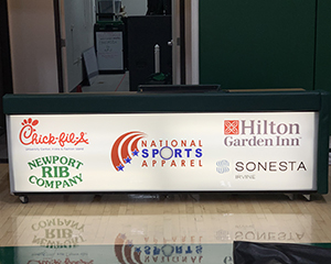 A graphic of 5 sponsors on the front of a scorer table