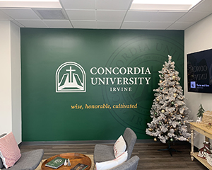 A green wall graphic. Text: Concordia University Irvine, wise, honorable, cultivated.
