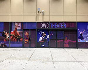 A window cling covering an entryway. Text: GWC Theater, Music, Dance.